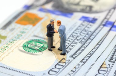 Amerikan Doları tokalaşırken işadamları. Para zemin üzerine işadamları figürler. Finans büyüme. İş kar veya gelir kavramı. Satın almak ve hareketleri nakit para için satmak. Yolsuzluk ödeme