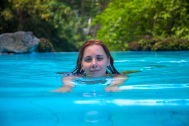 Rahat kadın açık yüzme havuzunda. Kamera seyir yüzme kız. Kız açık yüzme havuzunda. Yaz tatil deneyimi fotoğraf. Tropikal orman otel sahne. Egzotik tatil. Açık Yüzme Havuzu