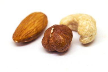 Beyaz arka plan üzerinde izole somun. Üç olgun somun closeup fotoğraf. Basit organik gıda. Lezzetli sağlıklı snack paket tasarımı. Dağınık somun çeşitler - kaju fıstığı, fındık, badem. Fındık afiş şablon