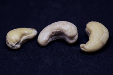 Kaşu fındık siyah arka plan üzerine izole. Üç olgun somun closeup fotoğraf. Basit organik gıda. Lezzetli sağlıklı snack paket tasarımı. Dağınık kaju clipart. Kaju banner şablon metin yer ile