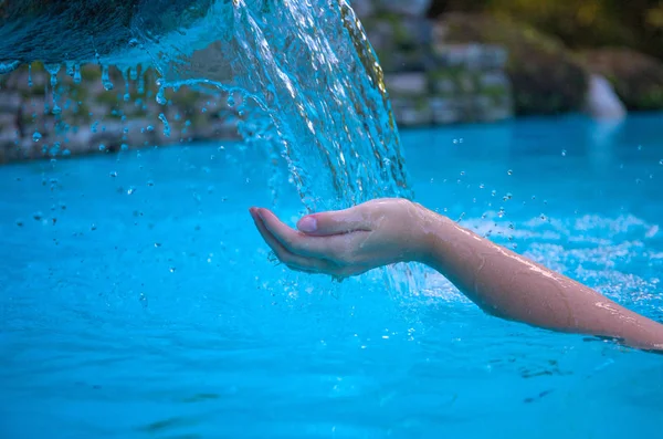 Woman hand and blue water. Cool water stream and hands. Fresh water current. Woman hands in clean flow. Hands hygiene concept photo. Calming moisture from natural water source. Summer refreshment