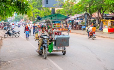 Siem Reap, Kamboçya - 31 Mart 2018: satıcı bir motosiklet şehrin sokak. Mobil eatery bisiklet. Gıda durak motosiklet üzerinde. Gezici sokak eatery. Asya iş düşük nitelendirir. Asya iş düşük ücretli