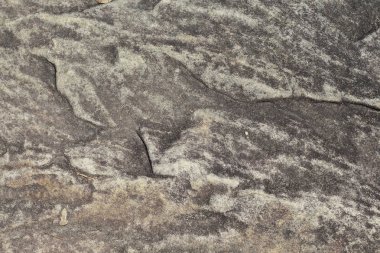 Gri kumtaşı doku fotoğraf. Doğal taş arka plan. Kaya kabartması yıpranmış. Cilalı kumtaşı yüzey portre. Taş doku sıkıntılı. Katı inşaat malzemesi. Aşınmış kaya oluşumu