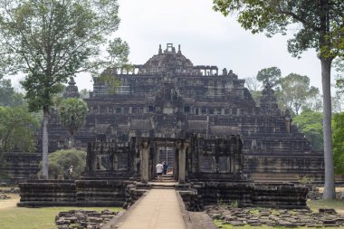 Angkor Wat Tapınağı harabe turist adam. Yeşil tropikal peyzaj antik tapınak Baphuon taş harabe. Khmer mimari miras. Kamboçya'da ilgi turistik yer. Asya seyahat gezi