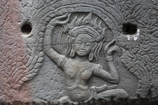 Ancient temple stone carved bas-relief in Angkor Wat. Dancing apsara woman bas-relief closeup. Angkor Wat temple architecture detail. Asia travel photo. Tourism sightseeing in Cambodia