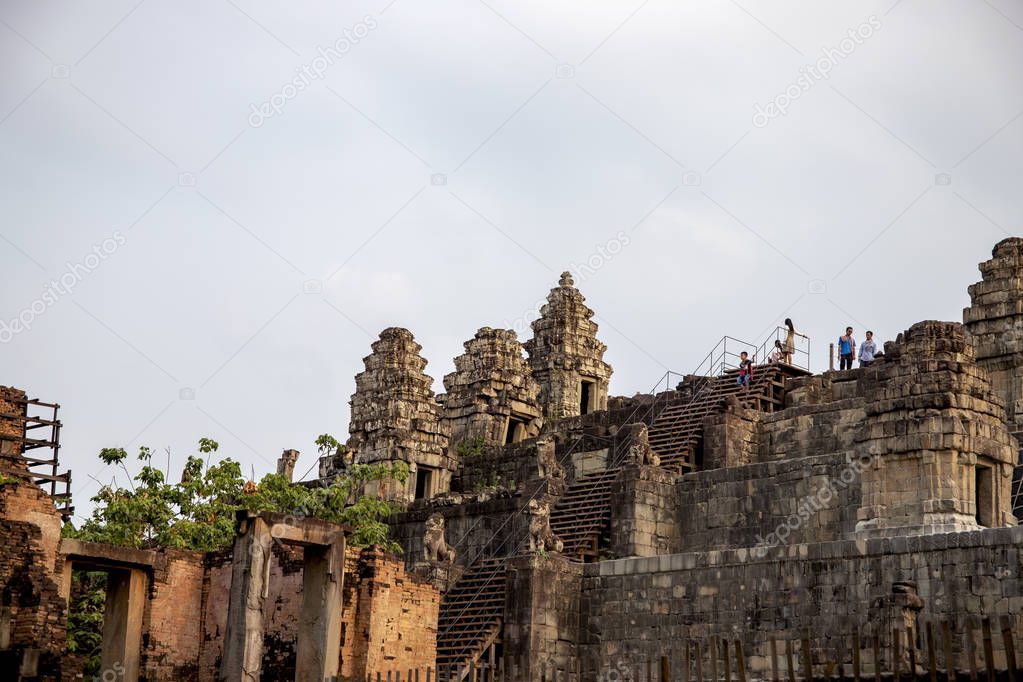 Siem Reap, Cambodia - 15 April 2018: tourists in Angkor Wat temple. Morning dew in Phnom Bakheng temple. Viewpoint hill in Angkor Wat. Khmer architecture legacy. Tourism travel and sightseeing in Asia