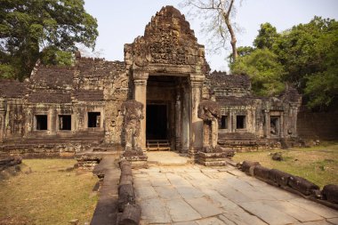Angkor Wat, Kamboçya 'daki Preah Khan tapınağının eski harabeleri. Taş kabartma ile dekore edilmiş giriş. Taş tapınak harabeye. Yeşil ormanda terkedilmiş tapınak. Asya 'da Turizm ve gezi yeri.