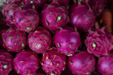 Rustik Pazar masasında pembe dragonfruit yığını. Olgun tatlı ejderha meyvesi. Renkli egzotik meyve yığını. Tropikal meyve pitahaya. Tatlı veya meyve suyu için pembe pitaya. Asya yerel pazar seyahat fotoğraf
