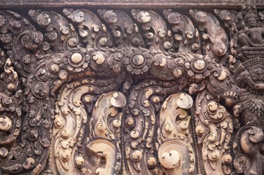 Angkor Wat, Kamboçya Banteay Srei tapınağının taş oyma bas kabartma. Geleneksel bas-kabartma closeup fotoğraf. Khmer mimarlık mirası detay. Taş oyma dekorlu antik yapı