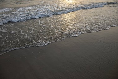 Deniz ve kumsallı turuncu gün batımı manzarası. Deniz kenarında gün batımı. Gün batımlı romantik bir deniz manzarası. Tropik adaya yaz seyahati. Denizde tropik gün batımı. Egzotik doğa manzarası