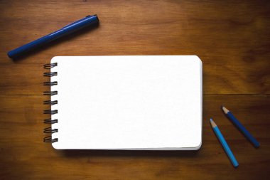 Tahta masa üzerinde kalem ve kalemlerle dolu beyaz kağıt defter, düz bir fotoğraf. Çizim tahtası ve çizim aletleri. Çizim defteri üst görünümünün boş sayfası. Sanat hobisi ya da çizim sınıfı afişi. Sanat modeli.