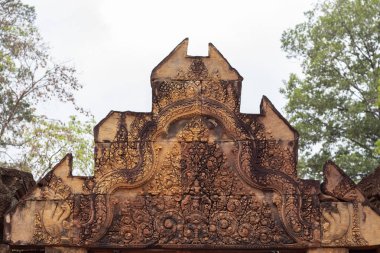 Angkor Wat, Kamboçya Banteay Srei tapınağının taş oyma bas kabartma. Çiçek süsbas-kabartma ile Çatı portalı. Khmer mimarlık mirası detay. Taş oyma dekorlu antik yapı