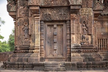 Taş Banteay Srei Tapınağı Angkor Wat, Kamboçya'nın kısma oyulmuş. Devata rakamlar ve çiçek süsleme kısma. Khmer mimari miras ayrıntı. Antik dekor oyma taş bina