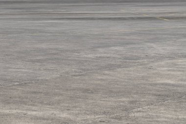 Boş asfalt Havaalanı yer. Grunge asfalt perspektif fotoğraf. Güneşli soluk gri asfalt arka plan. Sarı yol işaretleri olmayan beton yer. Havaalanı alan yolu. Modern uçak pist. Beton yüzey