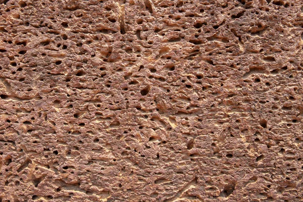 Porous sandstone surface. Ancient rough texture of natural stone. Weathered stone closeup. Rustic grungy surface photo background. Distressed texture of sandstone. Rough volcanic rock structure