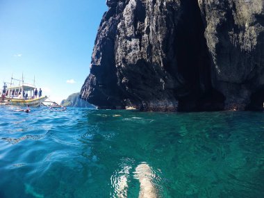 Tropik ada, yatay, deniz ve dağ. Mavi denize yakın mağara turist yüzmek. Palawan Adası spot gezi tekne turu. Deniz mağarada taşla. Volkanik ada deniz manzarası. Türkiye Seyahat