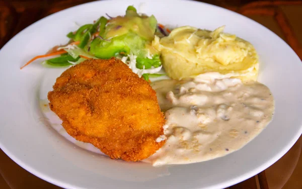 Schnitzel with mashed potato on white plate. Fried chicken cutlet top view photo on wooden table. Tasty lunch served for eat. Balanced food serve. Everyday nutrition. Meat and side dish in restaurant