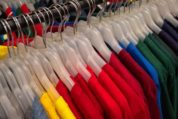 상점에서는 플라스틱 옷걸이에 색깔의 폴로입니다 시즌의 유니폼은 백화점에서 입는다 날씨에 — 스톡 사진