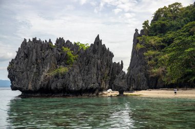 Beyaz kumlu plaj ve siyah uçurum ile sahil manzara. Palawan Adası, Filipinler tropikal kıyı şeridi görünümü