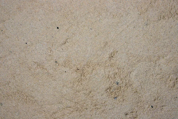 Arena amarilla granulada. Playa de arena de costa textura. Vista superior de la costa del océano foto. Fondo natural junto al mar — Foto de Stock