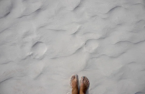 Woman feet on sand. Seashore sand beach texture. Ocean coast top view photo. Seaside natural backdrop — Stock Photo, Image