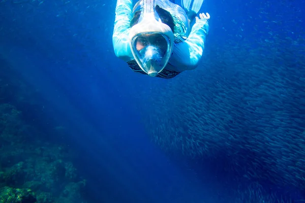 Mulher nadar com escola de peixe. Menina snorkeling em máscara de cara cheia. Snorkel com colônia de peixes foto subaquática — Fotografia de Stock