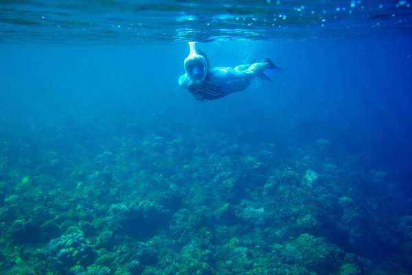 Woman dives in coral reef. Girl snorkeling in full-face mask. Snorkel person underwater photo. Snorkeling mask undersea — ストック写真