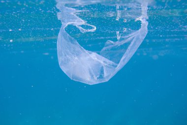 Mavi denizde plastik torba. Denizde çöp sualtı fotoğrafı. Plastik çöplü mavi deniz suyu. Ekoloji sorunu