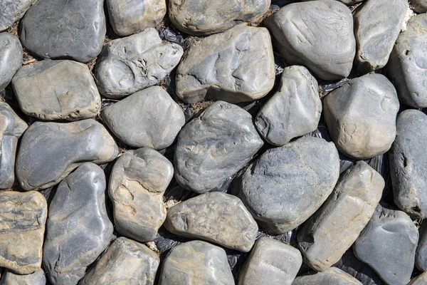 Grungy piedra foto textura. Rocas redondas vista superior fondo. Pavimento de piedra junto al mar. Carretera de costa marina . — Foto de Stock