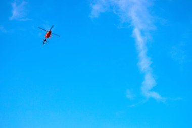 Mavi gökyüzünde kırmızı helikopter. Acil servis için özel ulaşım. İtfaiye helikopteri havalandı. Tıbbi acil taşıma.