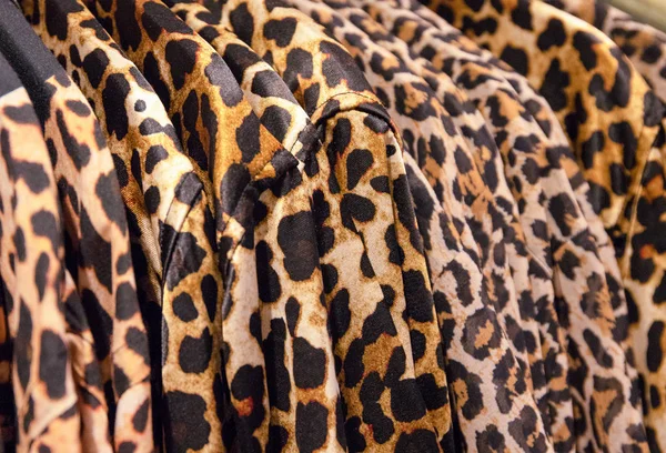 Leopard clothes on hangs in a fashion shop. Stylish animal print on top garment. Fashion shop Black Friday sale.