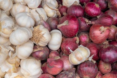 Beyaz sarımsak ve kırmızı soğan fotoğraf dokusu. Baharatlı yemek malzemesi. Beyaz sarımsak ve kırmızı soğan yığını..