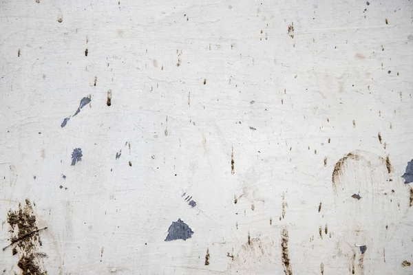 White painted wall with grit and stains, closeup photo texture. Corrosion and distressed marks on metallic surface Stock Image