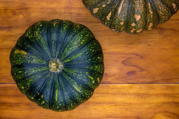 Green pumpkin top view photo on wooden background. Autumn garden harvest concept. Thanksgiving or halloween background — 스톡 사진