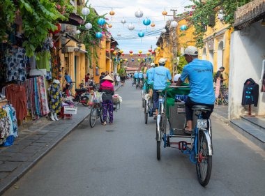 Hoi An, Vietnam - 28 Temmuz 2019: Çin fener dekoru, yerel halk ve testere ile eski kasaba caddesi.