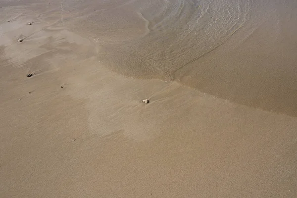 ビーチの砂と海潮の見通し。滑らかな黄色の砂の上に海の水。熱帯の海辺のコンセプト写真. — ストック写真