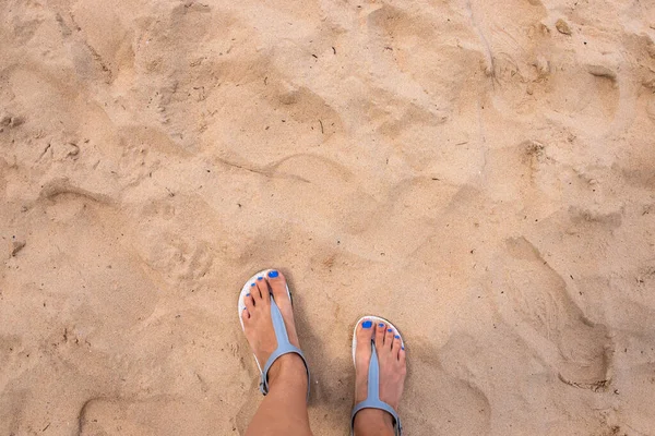 해변 모래와 여자가 맨 위에서 바라본다. 뜨거운 모래사장의 모래사장에 발을 디딘 소녀. 열 대의 섬 해안의 노란 모래 — 스톡 사진