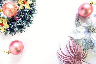 Noel bembeyaz arka planda yatıyordu. Nazik bir kadınsı Noel süsü masası manzarası. Pembe ve altın Noel mücevherleri