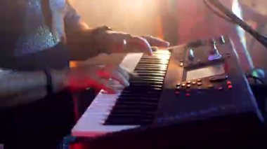 A keyboard player giving a live performance during a concert, emphasizing stage culture and passion for music