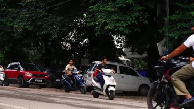 Fast motion timelapse of cars and motorbikes moving on a street in Dehradun, India, representing transportation and urban growth.