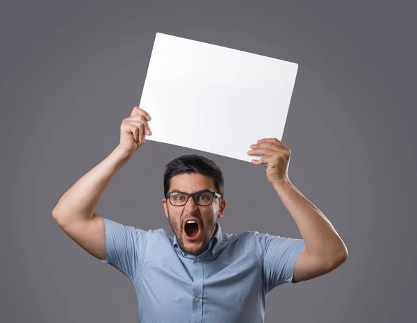 Beyaz boş poster başının üzerinde tutan genç deli brunet adam. Gereksinimleri ve talepleri olan insanlar. Gösteri insanları