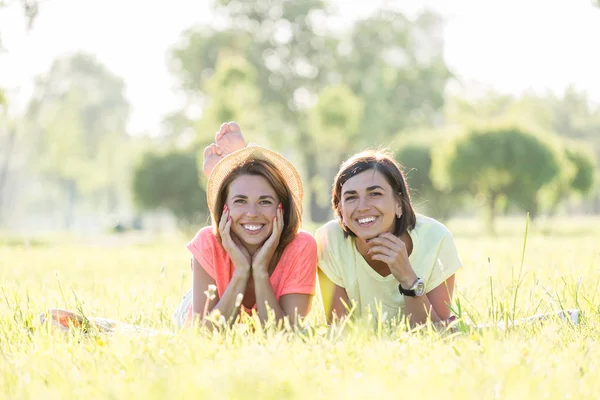 Duas Garotas Engraçadas Risonhas Deitadas Gramado Parque Verde Dia Quente — Fotografia de Stock