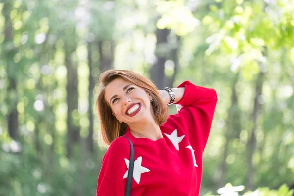 Jovem Menina Sorridente Bonito Camisola Vermelha Com Estrelas Posando Parque — Fotografia de Stock