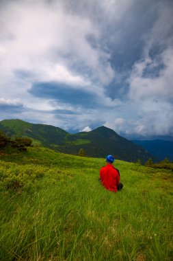 Maceracı yeşil çayır on ormanlık tepeler Panoraması hayran hangi ufuk düşük ağır bulutlar altında uzanan dinlendirici. Arkadan görünüm, geniş açı.
