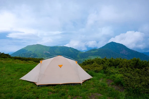 Yeşil dağ çayır ormanlık tepeler hangi ufuk - önce dağlarda düşük ağır bulutlar altında uzanan fırtına arka plan üzerinde çadır. Geniş açı.