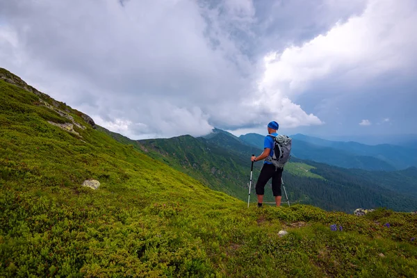 Avonturier Een Wandeling Langs Groene Bergrug Onder Lage Zware Wolken — Stockfoto