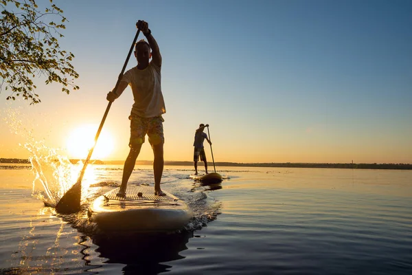 Mężczyzn Przyjaciele Żagiel Deski Sup Promieniach Wschodzącego Słońca Stand Paddle — Zdjęcie stockowe