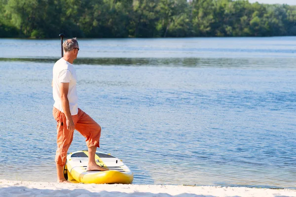 Ember Áll Egy Lapát Sup Táblán Strand Mellett Napfényes Reggel — Stock Fotó