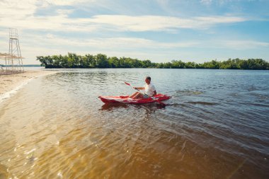 Bir güneşli sabah - su sporları tesisi üzerinde denizin plajın yanında bir kayık kürek çekmeye dostum. Geniş açı.