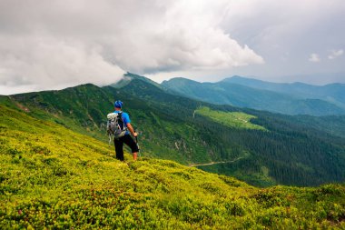 Maceracı ufka - dağlarda harika seyahat sise uzanır yeşil ridge hayran cliff üzerinde duruyor. Arkadan görünüm.